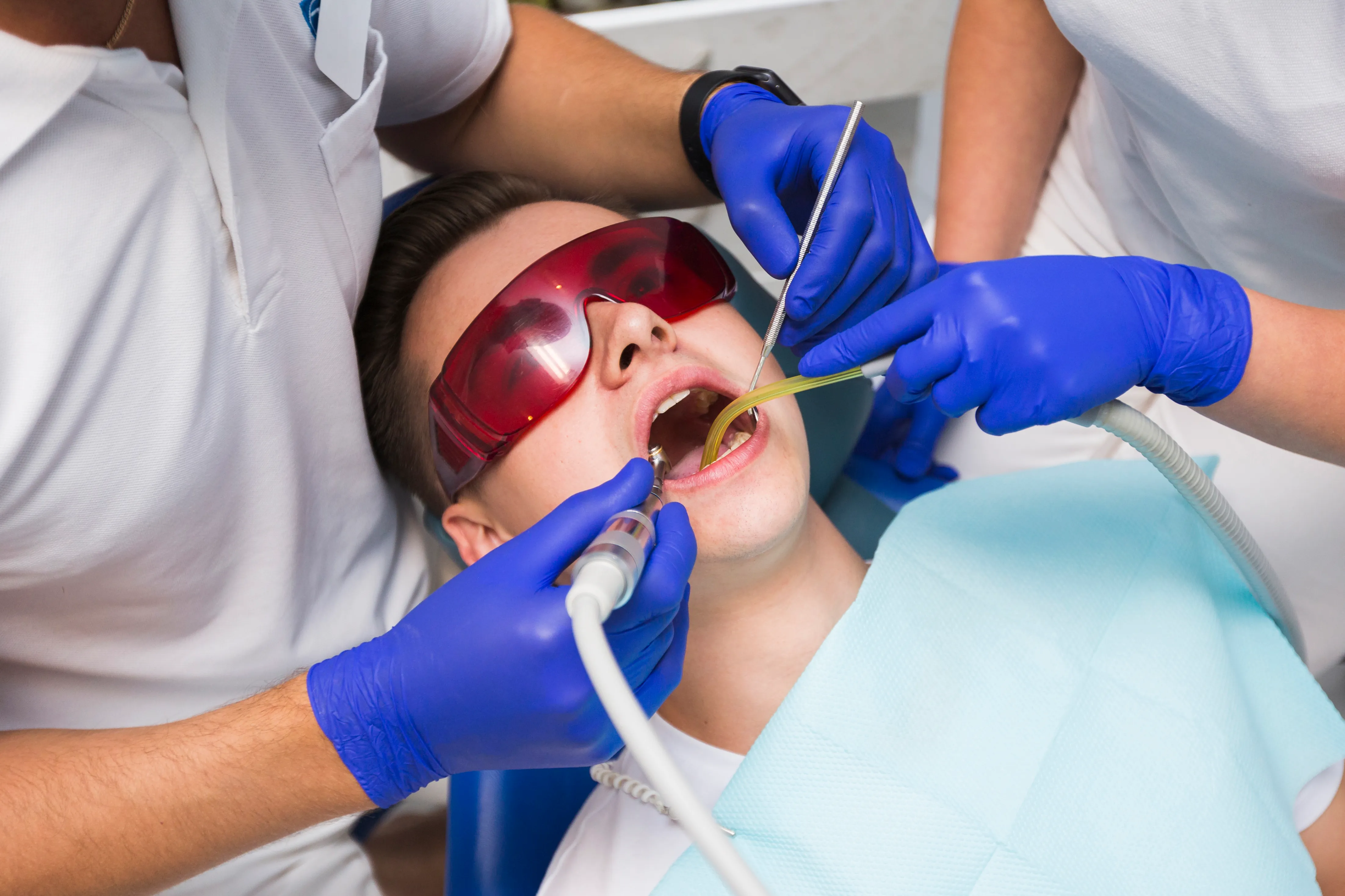 Patient undergoing professional dental cleaning with tools at aesthetic dental clinic